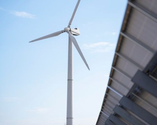 Wind turbine generating renewable energy with a clear blue sky background.